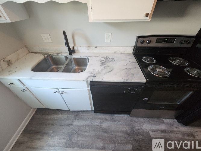 A kitchen with a sink and stove top oven.