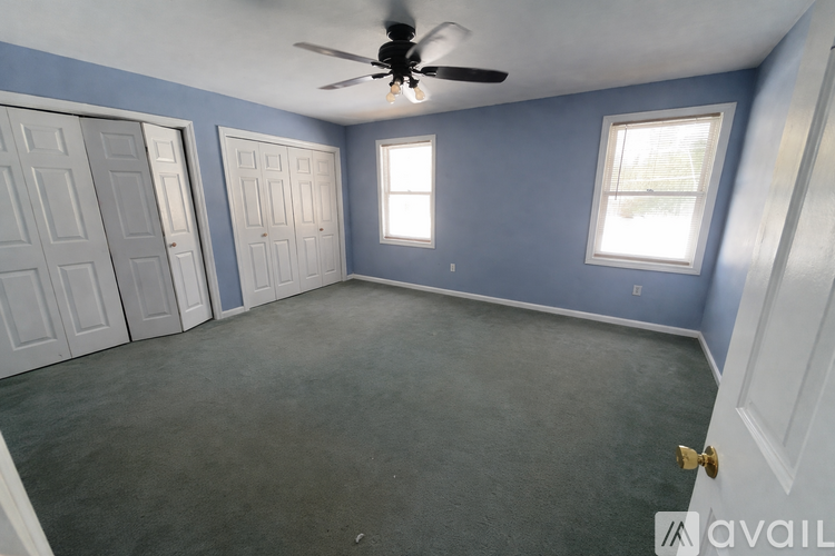 A room with a ceiling fan and two doors.