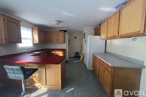 A kitchen with wooden cabinets and a red countertop.