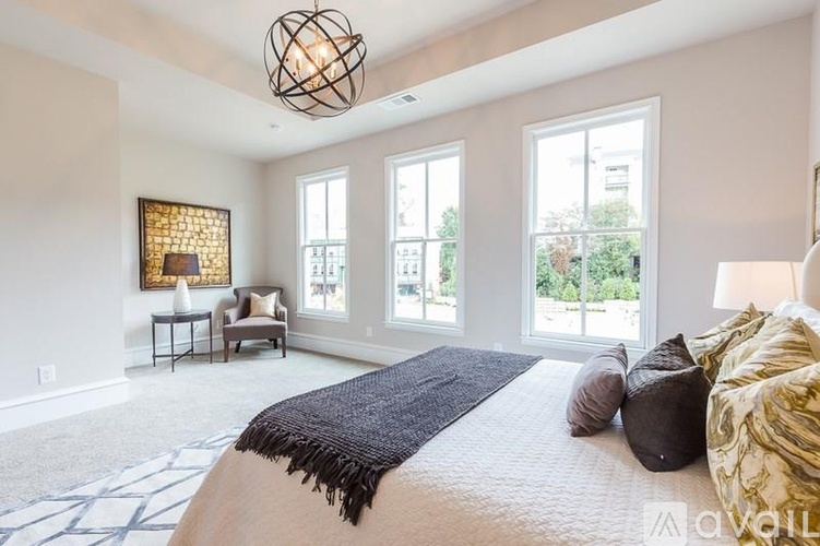 A bedroom with a large bed and a view of the outside through the windows.