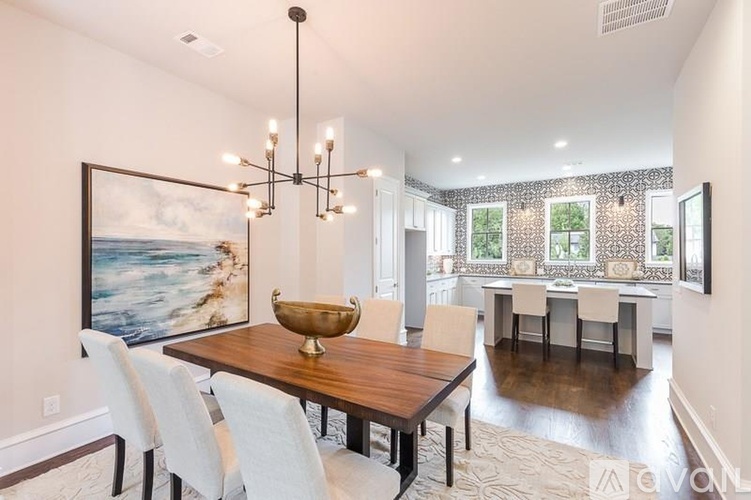 A dining room with a wooden table and white chairs.