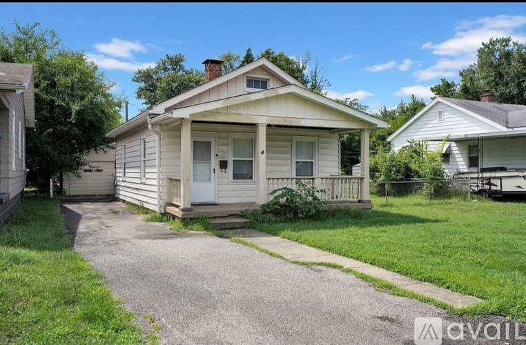 A house with a gravel driveway in front of it.