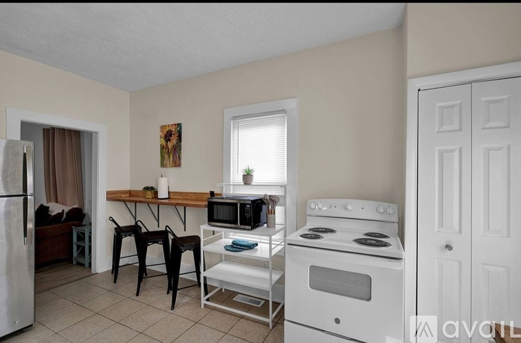 A kitchen with a white stove and a table with chairs.