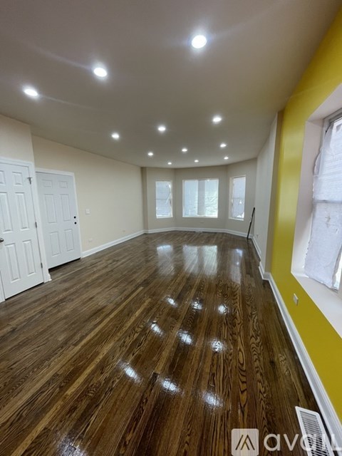 A room with wooden flooring and white walls.