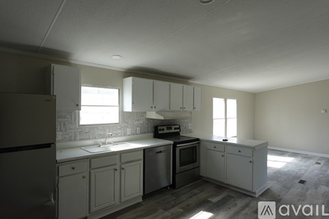 A kitchen with white cabinets and a stainless steel refrigerator.