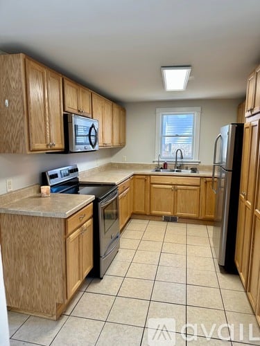 A kitchen with wooden cabinets and black appliances.