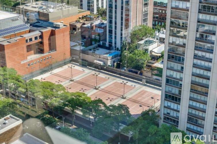 A view of a tennis court surrounded by buildings.