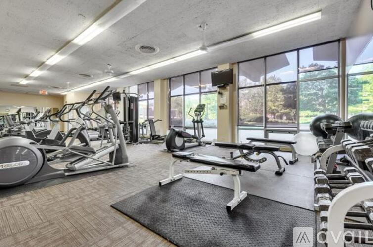 A gym with a variety of equipment including treadmills, weights, and exercise machines.