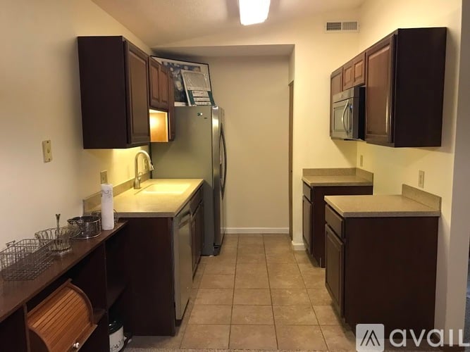 A kitchen with brown cabinets and a refrigerator.
