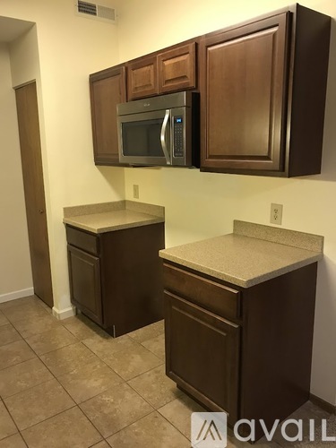 Brown cabinets with a microwave above them.