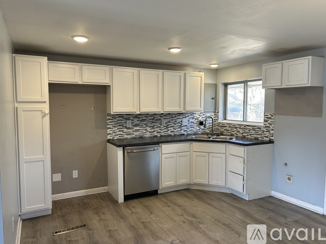A kitchen with white cabinets and a granite countertop is available.