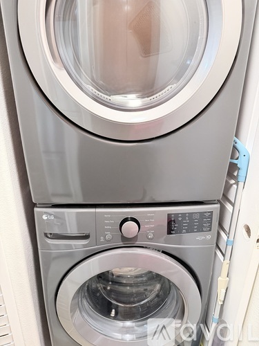 A front-loading washing machine with a transparent door and control panel.