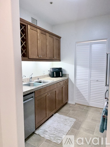 A kitchen with wooden cabinets and a white sink.