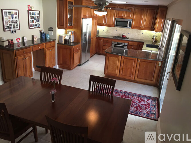 A kitchen with wooden cabinets and a dining table.