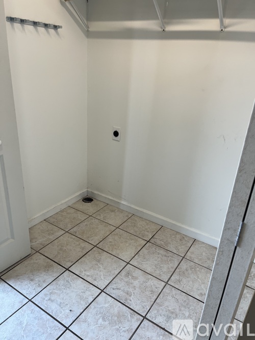 A bathroom with white walls and tiled floor.