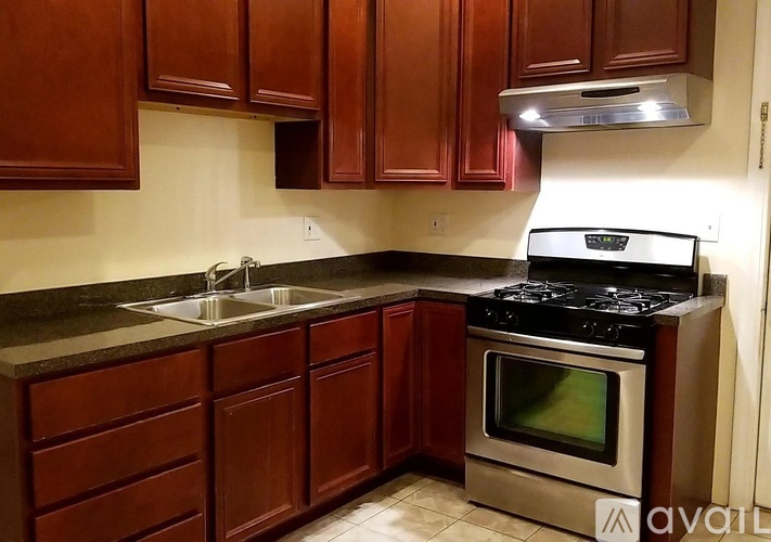 A kitchen with brown cabinets and a stainless steel oven.