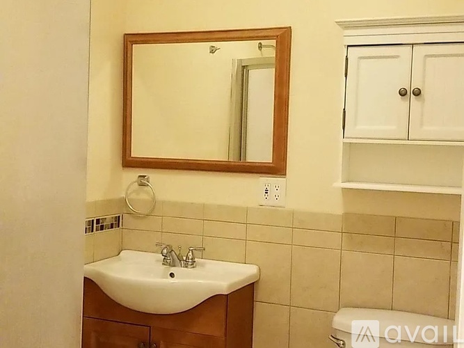 A bathroom with a sink, mirror, and toilet.