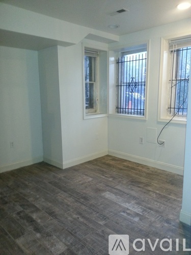A room with a window and a wooden floor.