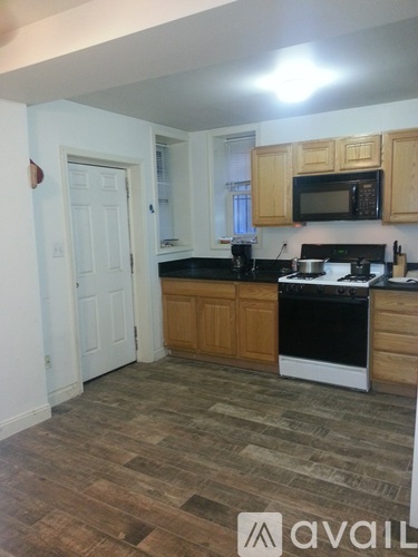 A kitchen with wooden cabinets and a black counter top.