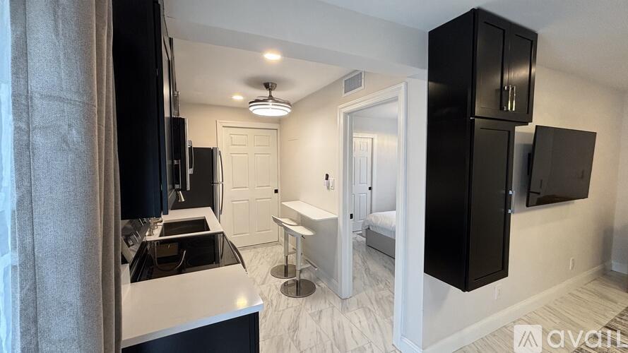A kitchen with black cabinets and a white countertop.