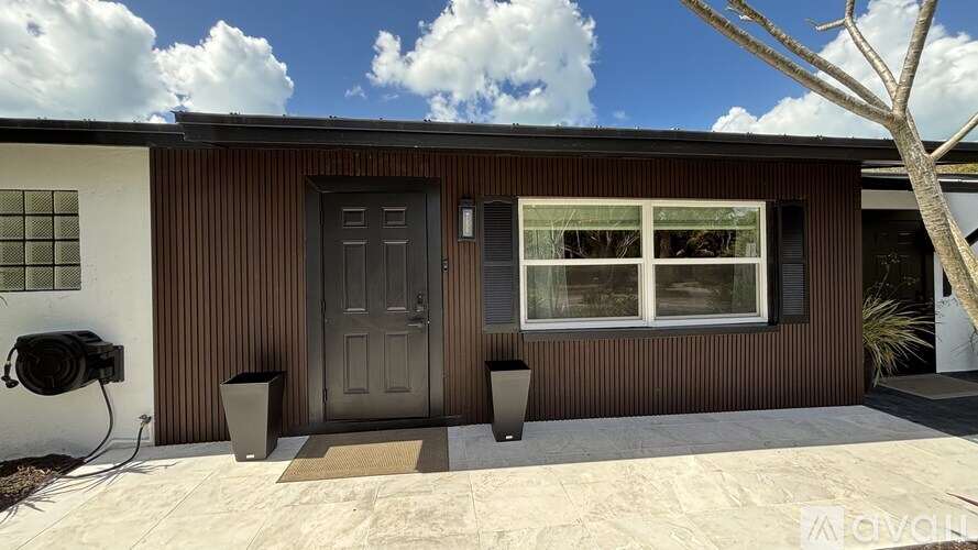 A house with a brown exterior and a grey door.