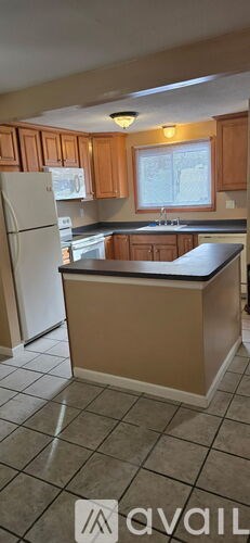 A kitchen with a white refrigerator and wooden cabinets.
