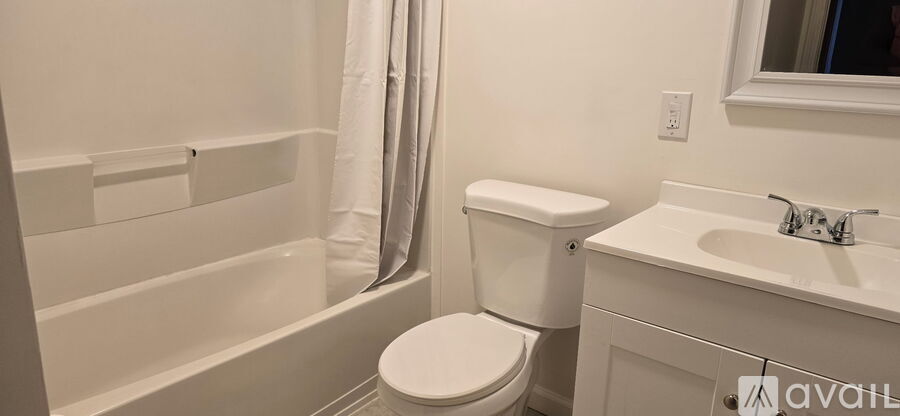 A white toilet sits next to a sink in a bathroom.