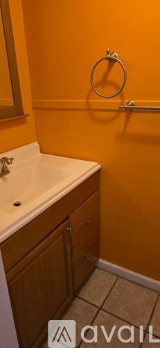 A bathroom with orange walls and a white sink.