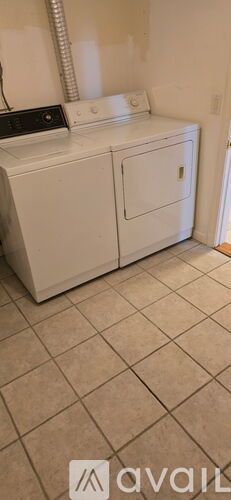 A white washing machine and dryer in a room.