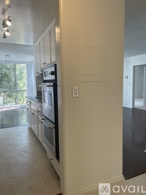 A kitchen with a black oven and white cabinets.