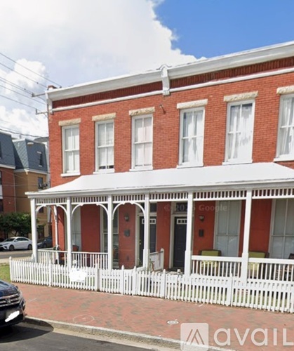 A red brick building with a white porch.