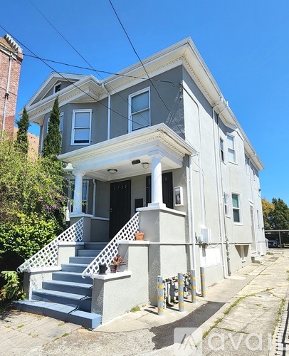 A two-story house with a front porch and stairs leading up to the entrance.