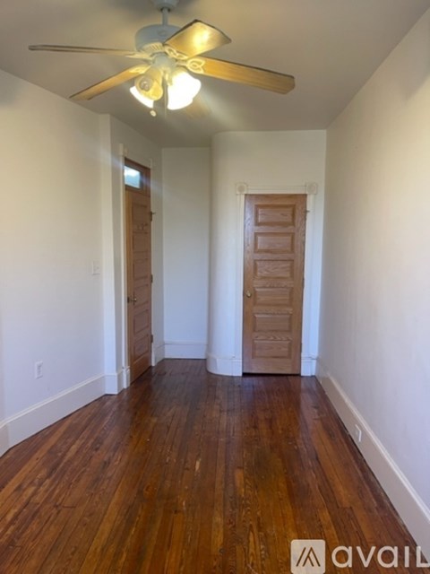 A room with wooden floors and a ceiling fan.