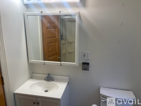 A bathroom with a sink, mirror, and toilet.