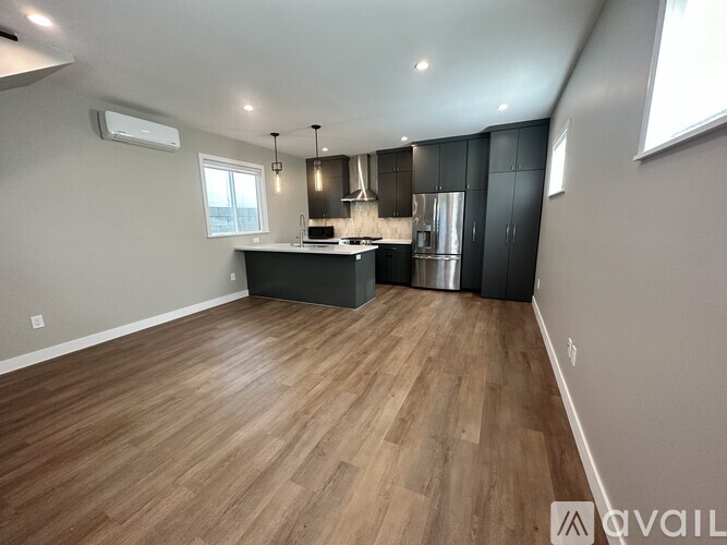 A kitchen with a refrigerator, stove, and cabinets.