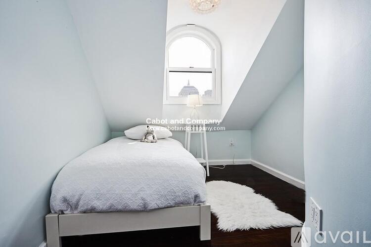 A bedroom with a bed, a window, and a chandelier.