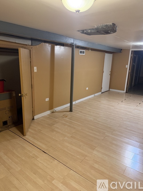 A room with wooden flooring and a ceiling light.