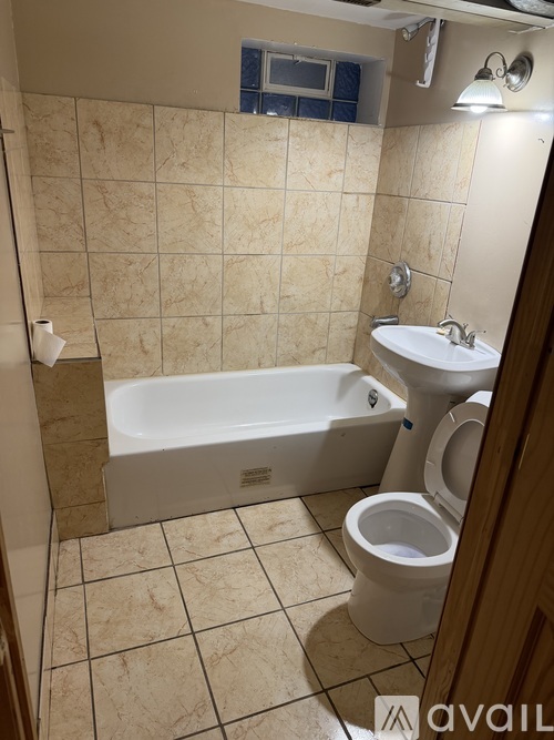 A bathroom with a toilet, sink, and bathtub.