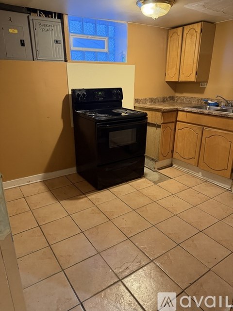 A kitchen with a black oven and brown cabinets.