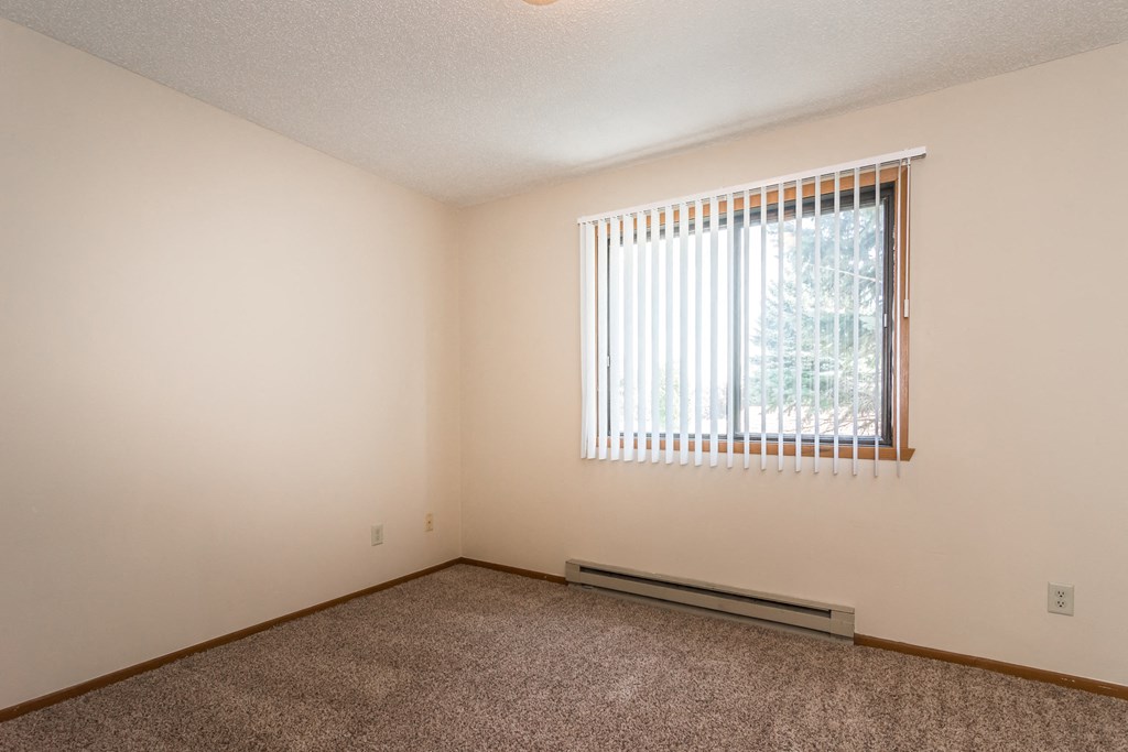 Grand Forks Kremer Apartments a bedroom with a large window and carpet