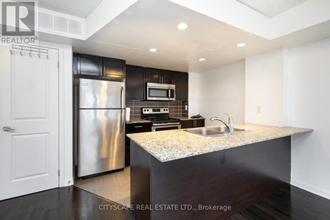 A modern kitchen with a stainless steel refrigerator and microwave.