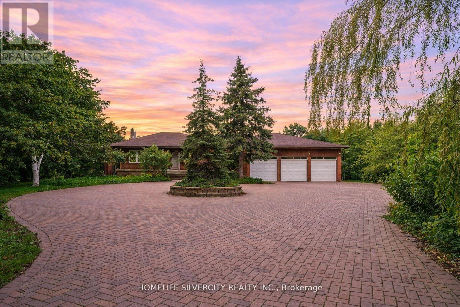 A driveway leads to a house with a garage.