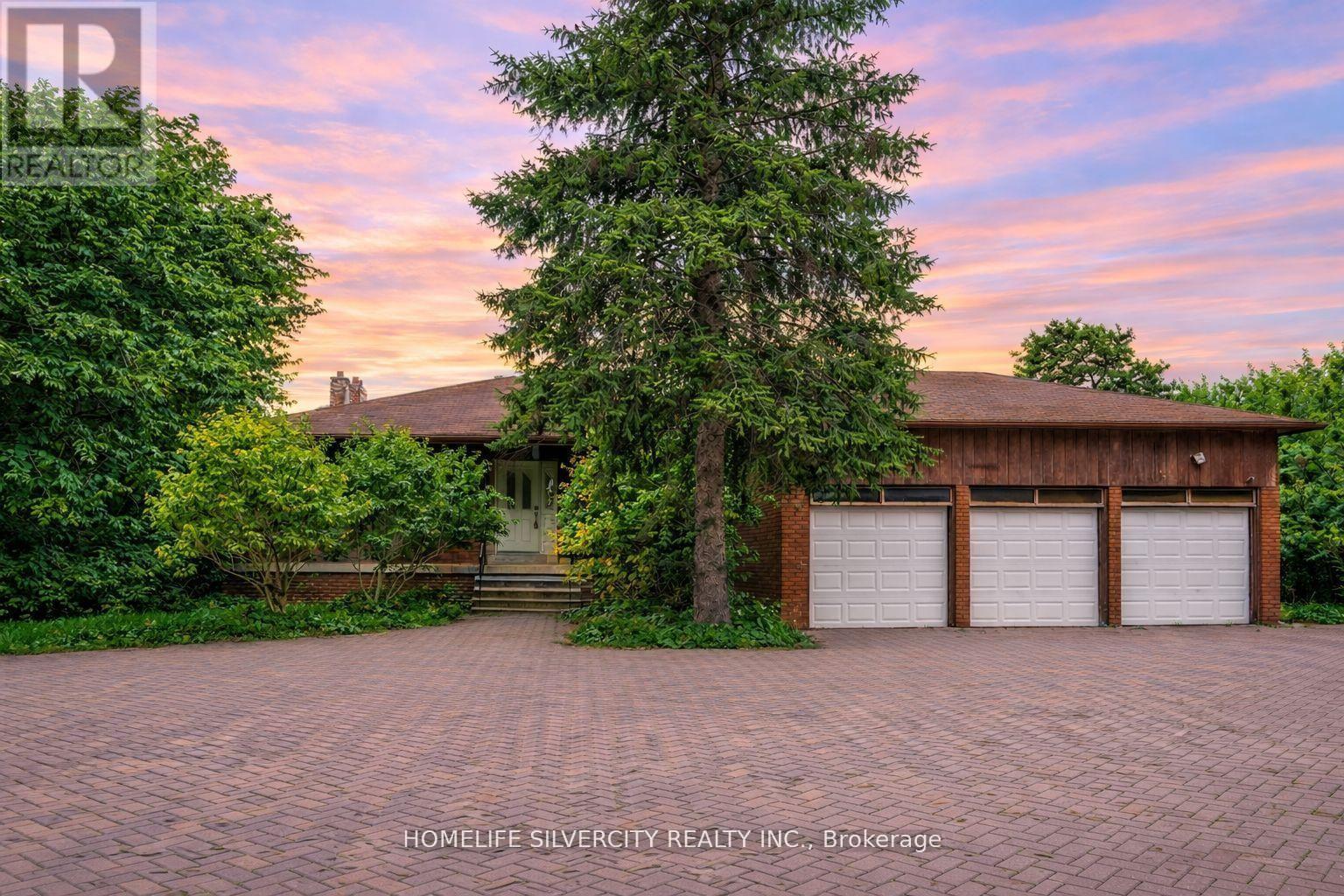 A house with a driveway and garage doors is for sale.