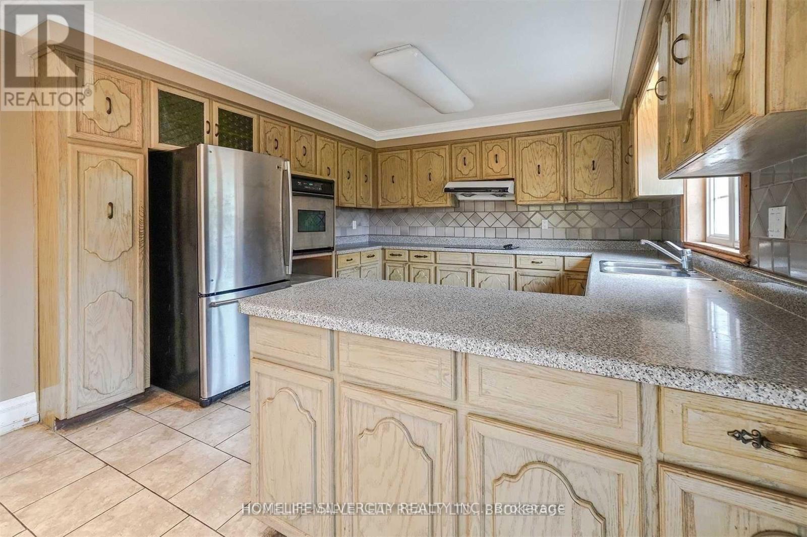A kitchen with wooden cabinets and a granite countertop.