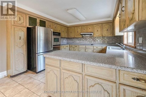 A kitchen with wooden cabinets and a granite countertop.