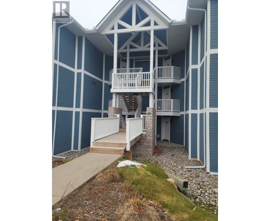 A blue and white building with a balcony and stairs.