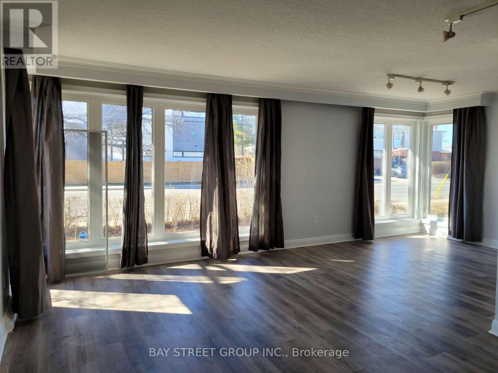 A room with a large window and curtains, with the logo "REALTOR" on the top left corner.