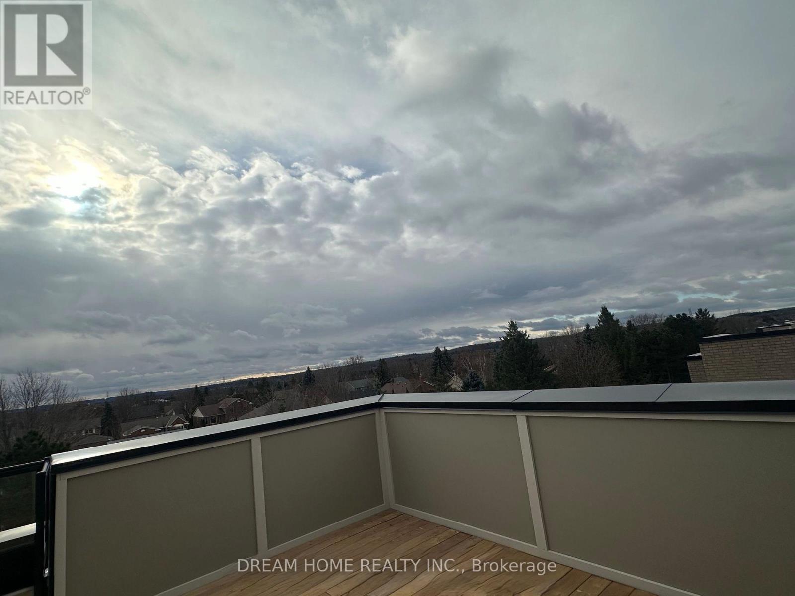 A balcony with a view of the sky and trees.
