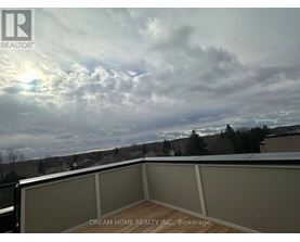 A balcony with a view of the sky and trees.