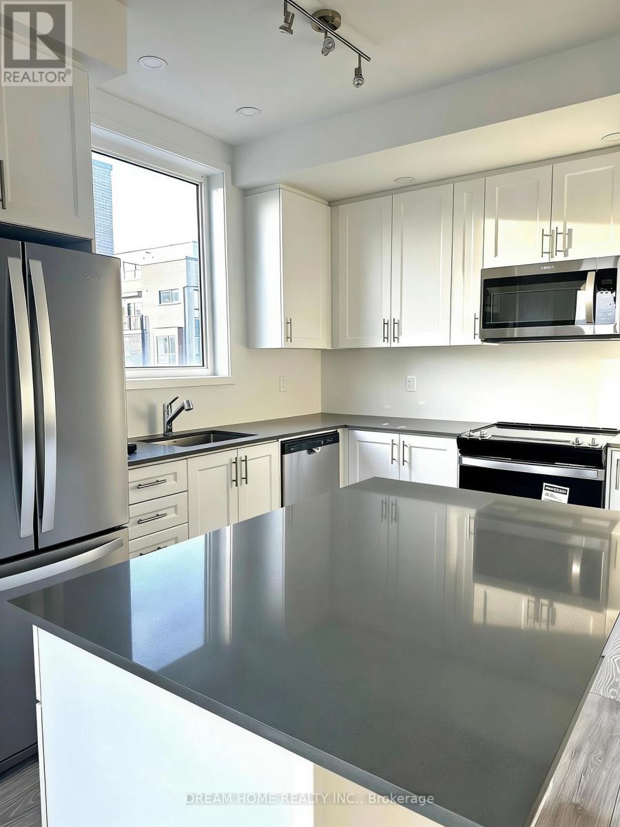 A kitchen with a stainless steel counter top and white cabinets.